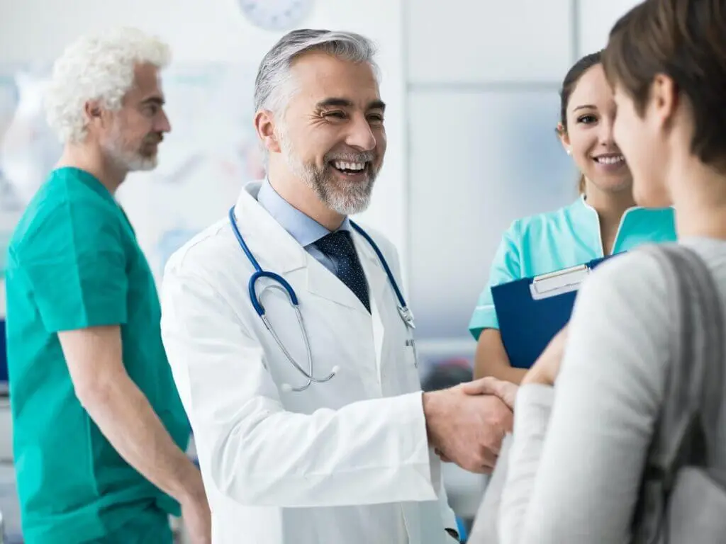 Confident doctor shaking patients hand