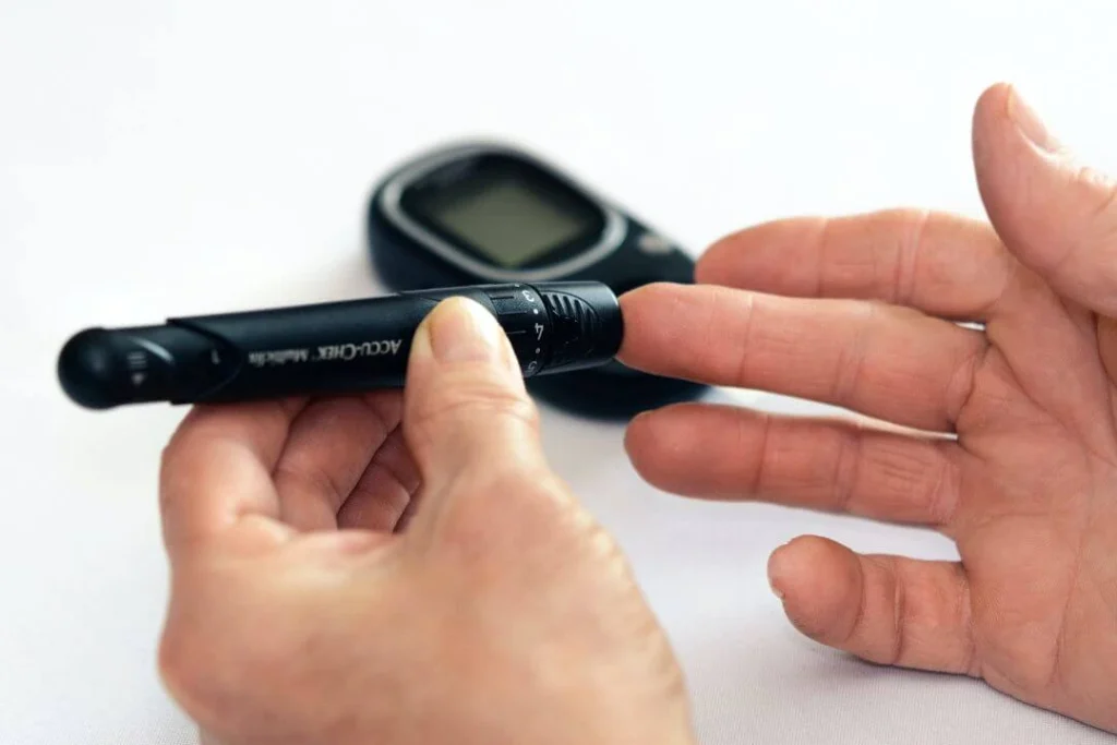 Person using a blood glucose meter to check their blood sugar levels.