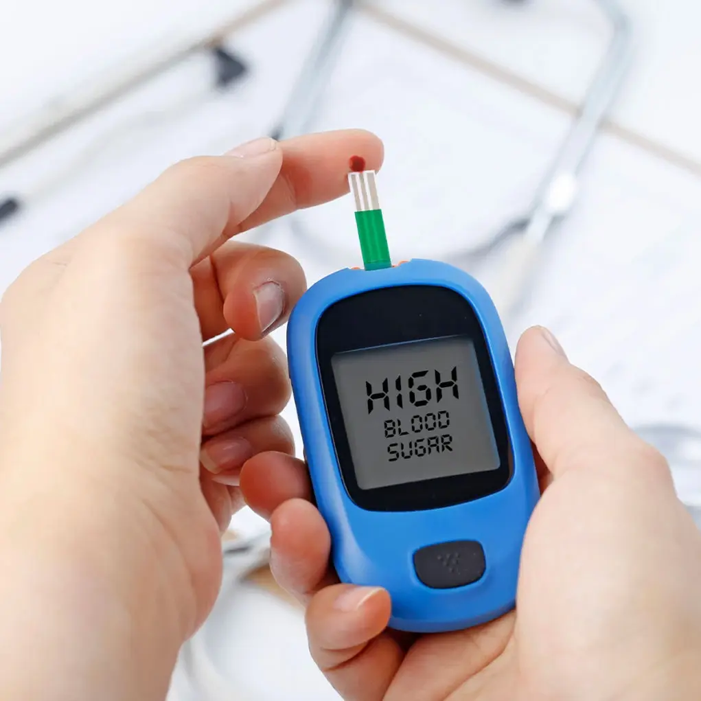 Person holding a glucose meter with the text "HIGH BLOOD SUGAR" on the screen.