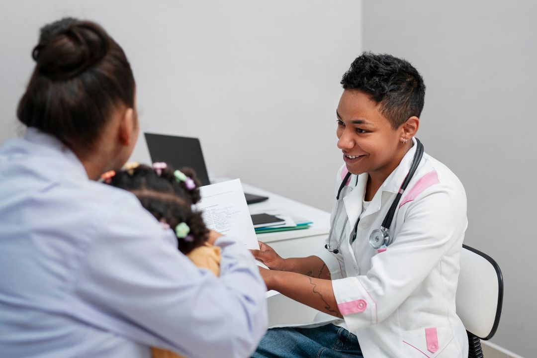 Smiling doctor discussing paperwork with young patient.