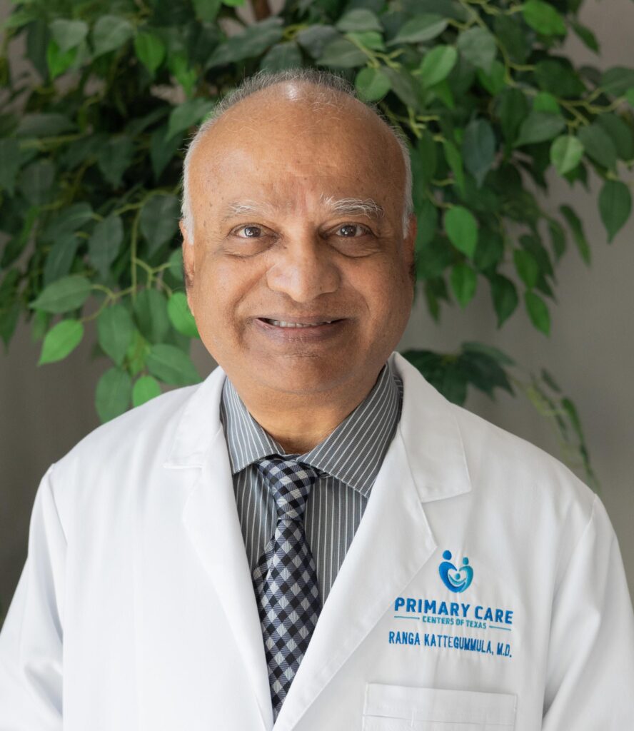 Male doctor wearing white coat, smiling confidently.