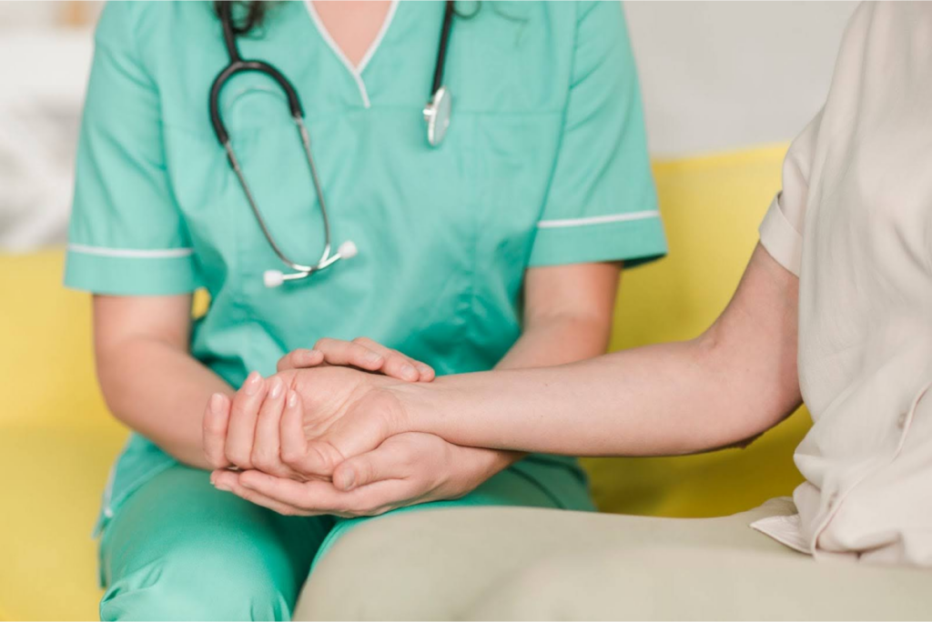 Nurse holding a patient's hand.