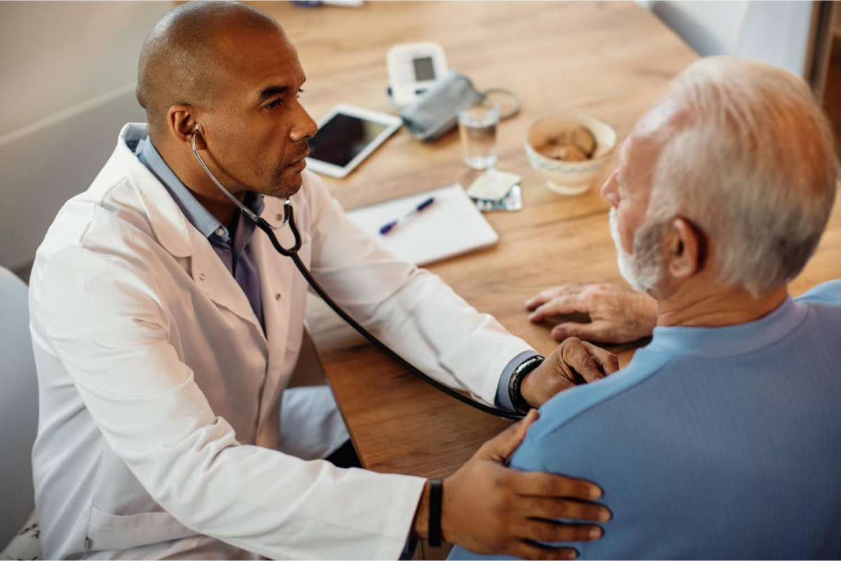 A doctor using a stethoscope to examine an elderly patient.