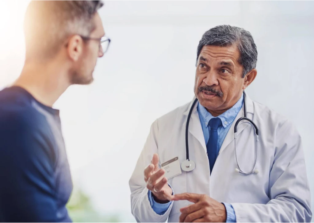 A doctor explaining medical information to a male patient.