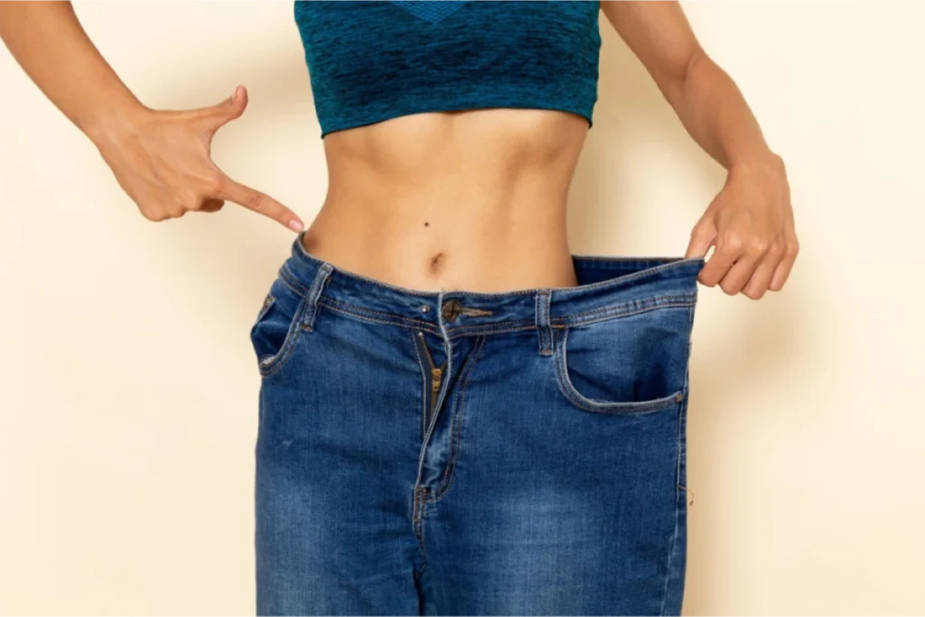 A person wearing loose jeans, showing significant weight loss.