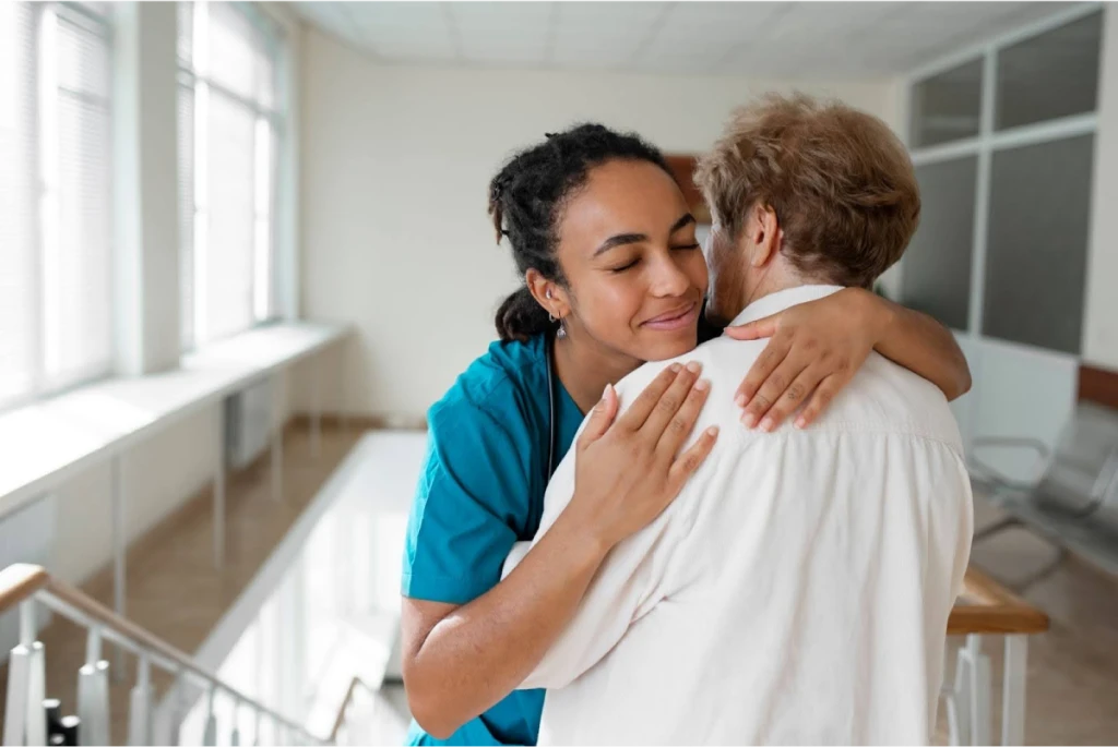 Nurse embracing an elderly patient.