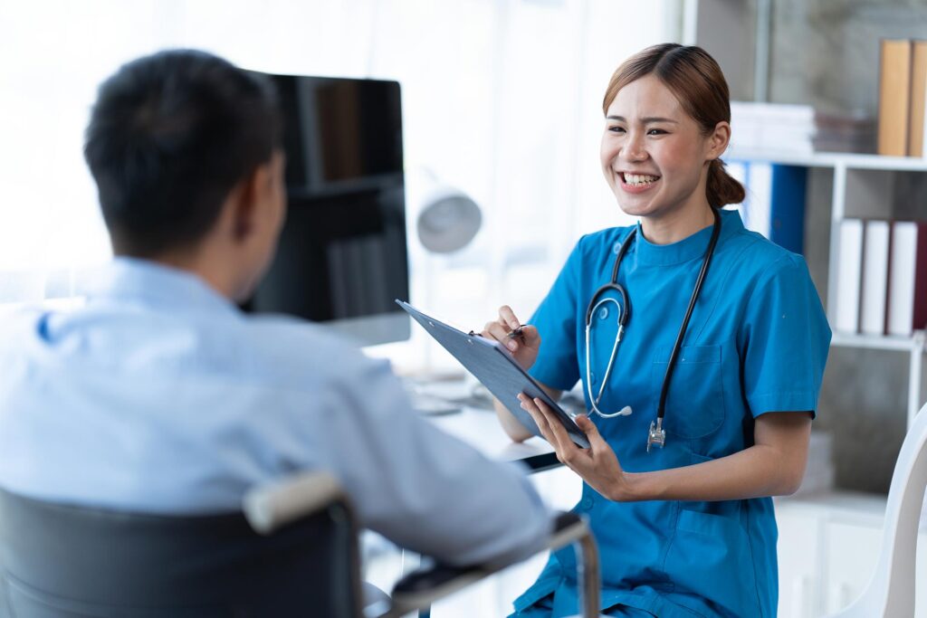 Smiling nurse consulting patient with clipboard.