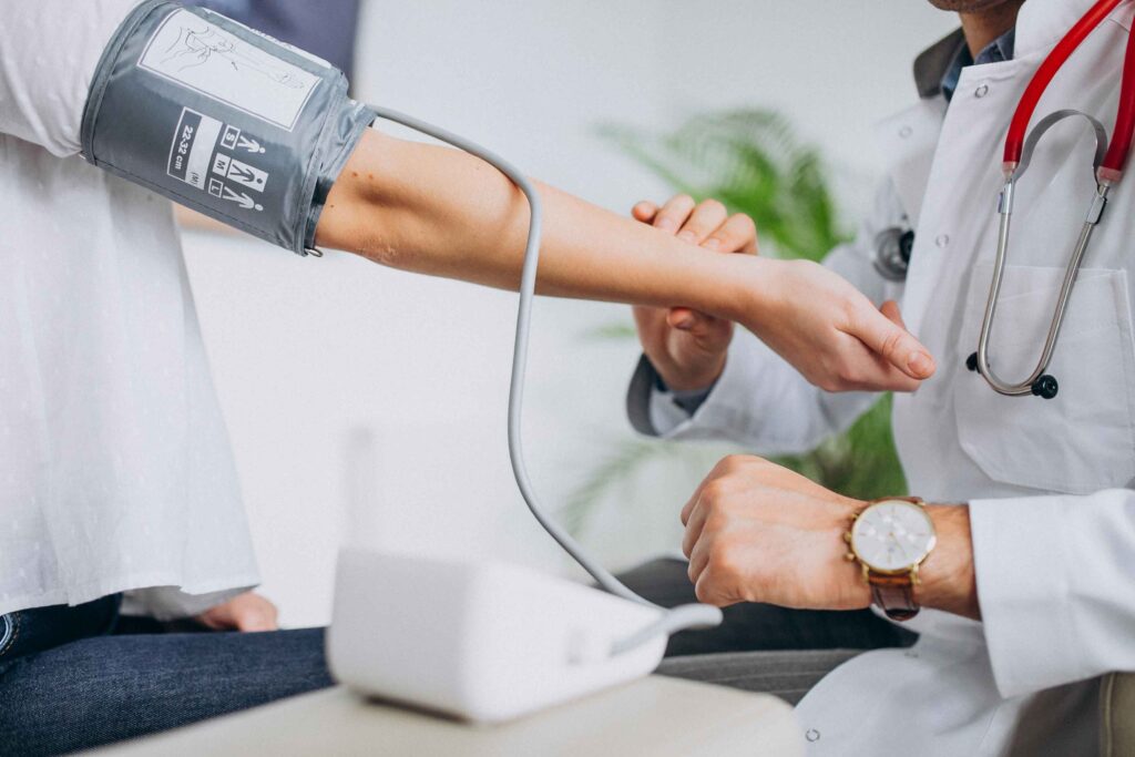 Doctor taking blood pressure of a patient.