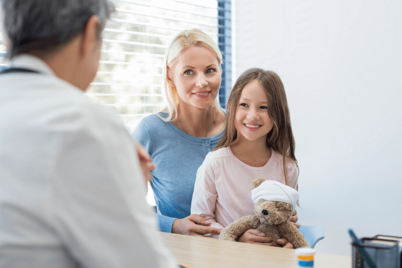 Mother and daughter in consultation with doctor.